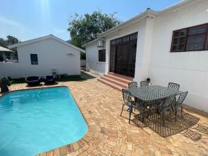 a patio with a table and chairs next to a house at Franschhoek Mountain Escape in Franschhoek