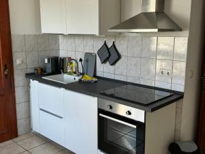 a kitchen with white cabinets and a sink and a stove at Altbauapartment in Wassernähe und Magenta TV in Brandenburg an der Havel