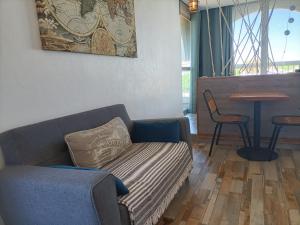 a living room with a couch and a table at Le Sémaphore - studio climatisé, grande terrasse vue mer - parking, wifi in La Grande Motte