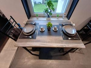 a wooden table with utensils on top of it at City Apartment Paderborn Apartment 6 in Paderborn