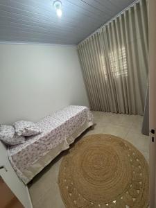 a small bedroom with a bed and a rug at Cantinho do Sossego in Uberlândia