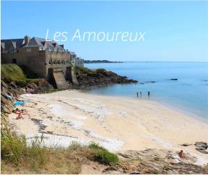 una playa con un edificio y gente en el agua en Bel Appartement face mer, en Billiers 8 fotos más