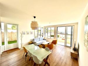 una sala de estar con un sofá, una mesa y sillas en Bel Appartement face mer, en Billiers