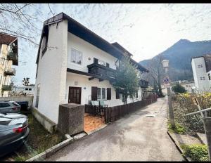 a white house with a balcony and a driveway at Small studio for two - Ferienwohnung für Zwei in Bad Reichenhall