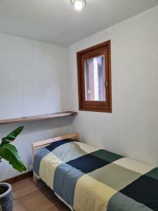 une chambre avec un lit et une fenêtre dans l'établissement Le refuge, à Samoëns