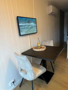 a dining room table with a bottle and a chair at Beach House Hillasol DISHOEK in Koudekerke