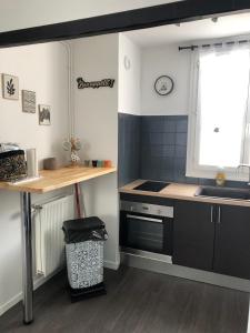 a kitchen with a sink and a stove top oven at Le Nid Douillet in Compiègne