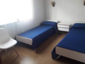 a bedroom with two beds and a table and a chair at Casa en Barrio Privado Hipocampo in Villa Gesell +15 photos