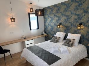 ブーグネにあるLa Maison Blancheのベッドルーム1室(青い壁の白いベッド1台付)
