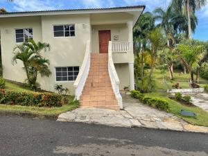una casa con una escalera que conduce a la puerta principal en Villa Amour, en Sosúa