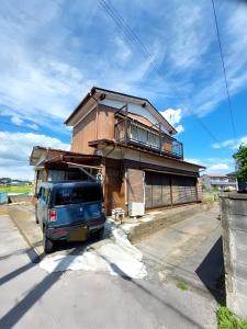 Satteつきびとはうす的停在房子前面的一辆蓝色面包车