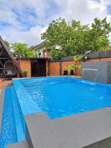 AnulingWooden Camp Resort-Alfonso Cavite的房子里有蓝色水的游泳池