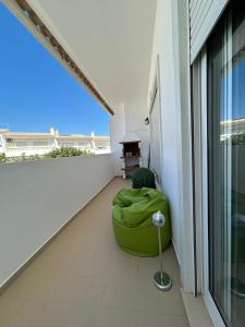 een groene zitzak op een balkon bij Apartamento Rota do Sol in Armação de Pêra