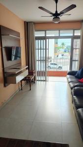 een woonkamer met een bank en een piano bij Praia Grande Boqueirão e Guilhermina in Praia Grande