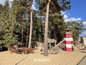 Un parque infantil con un tobogán y un faro en una playa. en Lena`s Ferienhaus, en Stüde
