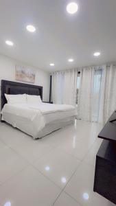 1 dormitorio blanco con 1 cama grande y ventanas en Stylish house close to tourist attractions, en La Libertad