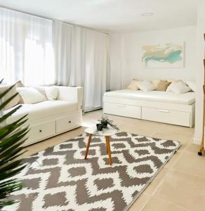 a living room with two beds and a rug at Costa by Hawkins Algeciras - Exterior 2A in Algeciras
