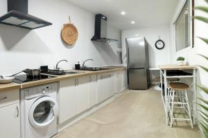 a kitchen with a washing machine and a refrigerator at Costa by Hawkins Algeciras - Exterior 2A in Algeciras +7 photos