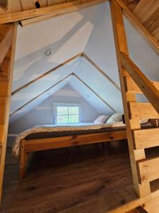 a bed in a loft bed room in a house at Roztoczański Domek in Zwierzyniec