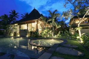 a villa with a swimming pool at night at Masia Villa Ubud in Ubud