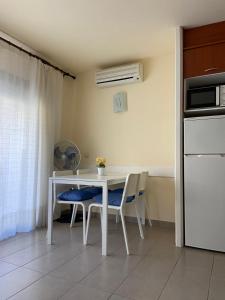 a kitchen with a white table and chairs and a refrigerator at Estartit Jardins del mar 51 in L'Estartit