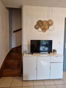 a living room with a tv on a white cabinet at MARINA ILE DES PECHEURS in Le Barcarès