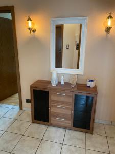 a bathroom with a wooden dresser and a mirror at Ferienwohnung an der Nordsee in Schortens +13 photos