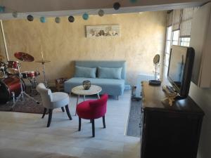 a living room with a blue couch and a tv at Les jardins de Shambhala in Montrem +26 photos