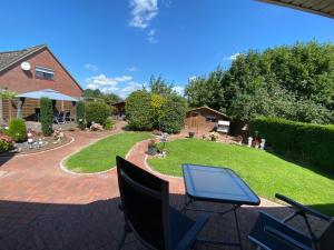 a table and chairs on a patio with a yard at Ferienwohnung an der Nordsee in Schortens
