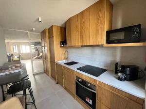 a kitchen with wooden cabinets and a counter top at MindeloThePalm in Mindelo