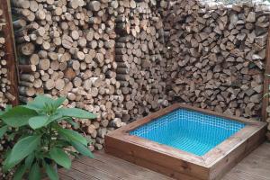 a pile of wood with a wooden tub next to a wall at Rõtu saunamaja in Leeskopa