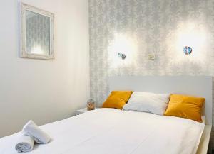 ein Schlafzimmer mit einem weißen Bett und gelben Kissen in der Unterkunft Cozy Hideout - Condo Hotel in Timişoara