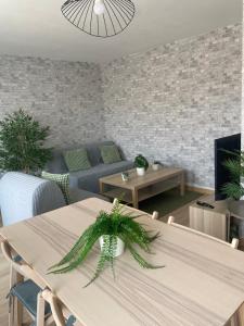 a living room with a table and a couch at Chez Douddine in Pont-du-Château +3 photos
