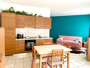 a kitchen with a table and a pink couch at Appartamento Decanter in Tirano