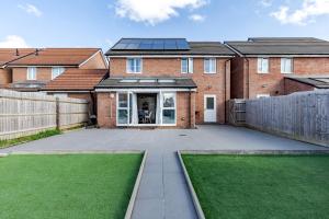 a brick house with a solar roof and a yard at Luxurious 2 Bed House near Birmingham in Bilston