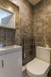 a bathroom with a toilet and a sink and a mirror at Luxurious 2 Bed House near Birmingham in Bilston