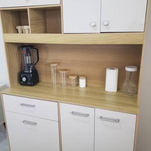 a cupboard with a coffee maker and glasses on it at Casa Indaiá in Primavera do Leste