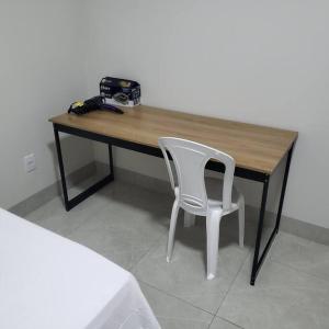 a wooden desk with a white chair next to it at Casa Indaiá in Primavera do Leste +11 photos