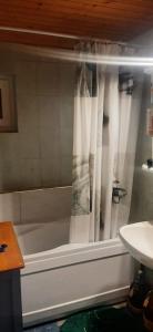 a bath tub with curtains in a bathroom at Fehér-kék hibiszkusz in Páka