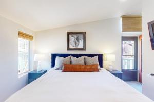 a bedroom with a large white bed with two lamps at East Vail Escape in Vail