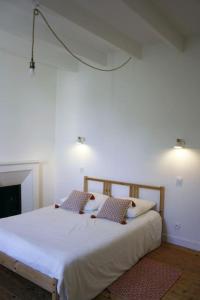 a bedroom with a large white bed with two pillows at Le Carrouge, jolie maison cancalaise in Cancale