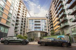 two cars parked in front of tall buildings at Contemporary Penthouse in Battersea Power Station in London