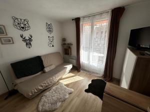 a living room with a couch and a window at Studio Risoul 1850 in Risoul