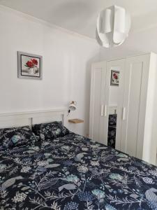 カルカヴェロスにあるVivenda BRANCAのベッドルーム1室(青と白の掛け布団付きのベッド1台付)