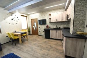 a kitchen with a table and yellow chairs in it at Студио Анастасия in Smolyan