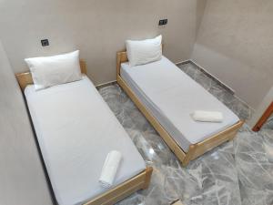 two beds in a room with white sheets and pillows at Sea Breeze 4 in Imsouane