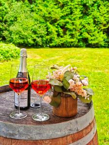 - deux verres de vin et une bouteille sur un fût dans l'établissement Walk to Lake - Old Town Retreat, à Niagara on the Lake