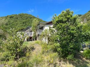 a house on the hill with trees in the foreground at Picturesque Waikawa - Picton Holiday Home in Picton