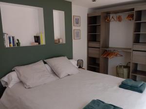 a bedroom with a white bed and a green wall at Loft pays basque in Anglet