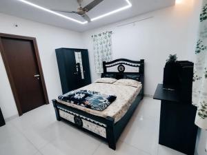 a bedroom with a black bed in a white room at Skyline View Suite in Hyderabad